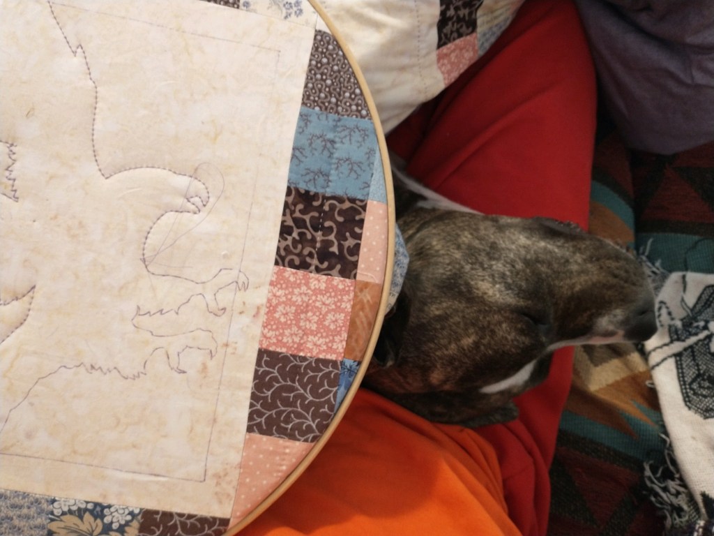 dog laying under quilt